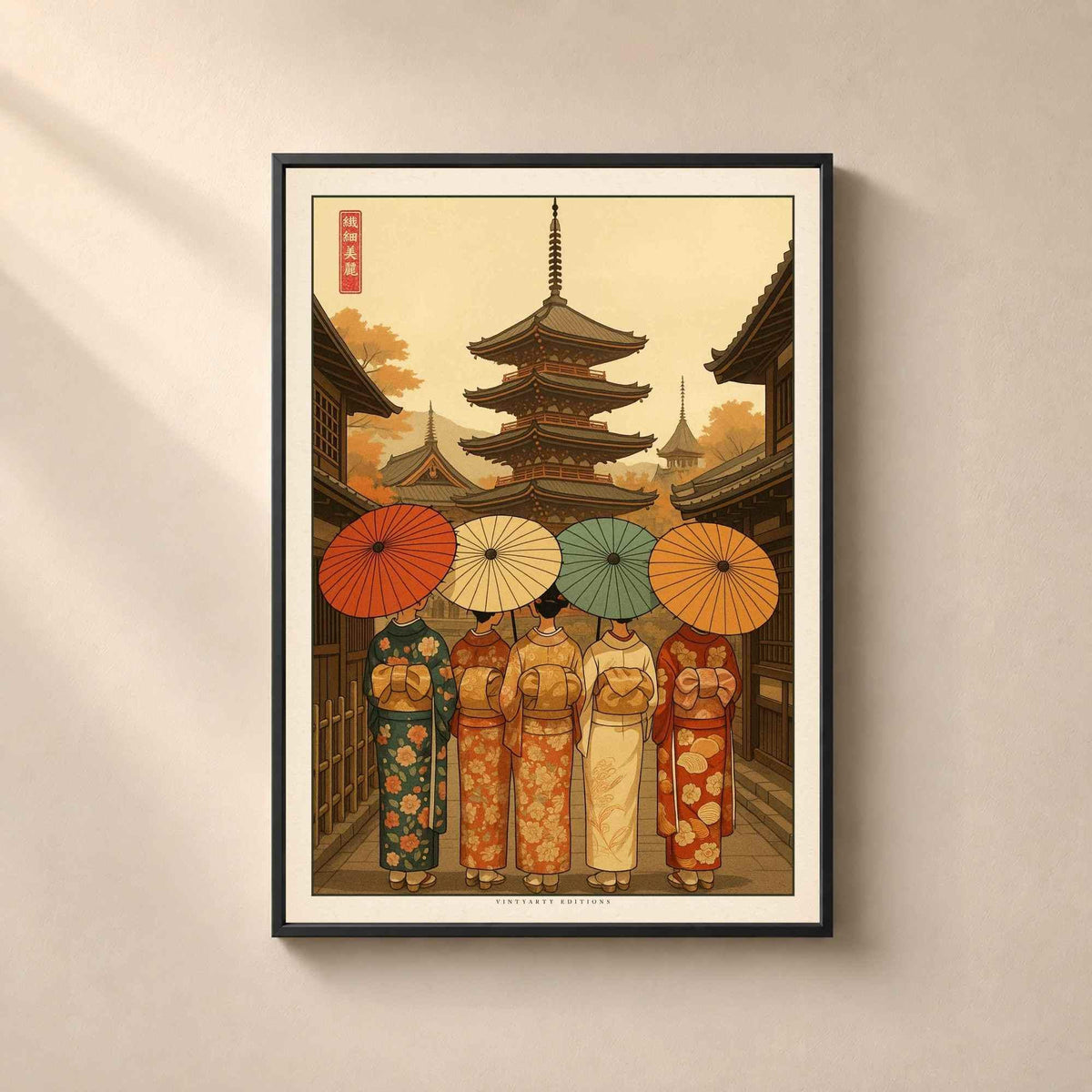 Affiche Kyoto encadrée en métal noir fin sur un mur beige, cinq femmes en kimono avec ombrelles devant une pagode à cinq étages en automne.
