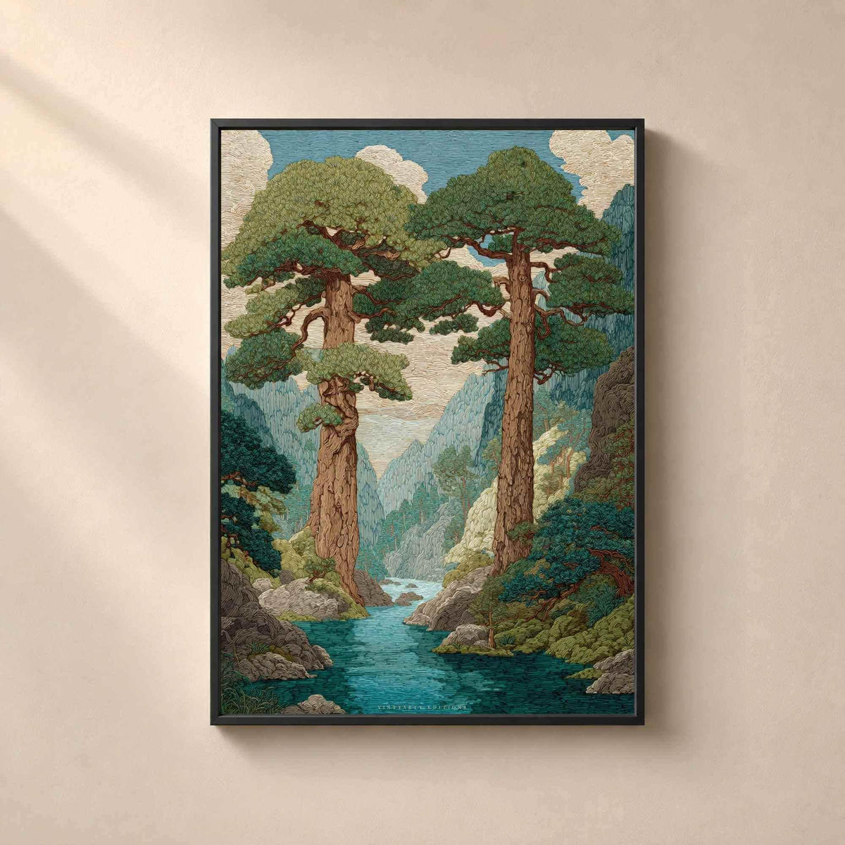 Affiche paysage japonais encadrée en métal noir fin sur un mur beige, deux grands pins au-dessus d'une rivière turquoise dans une vallée boisée.