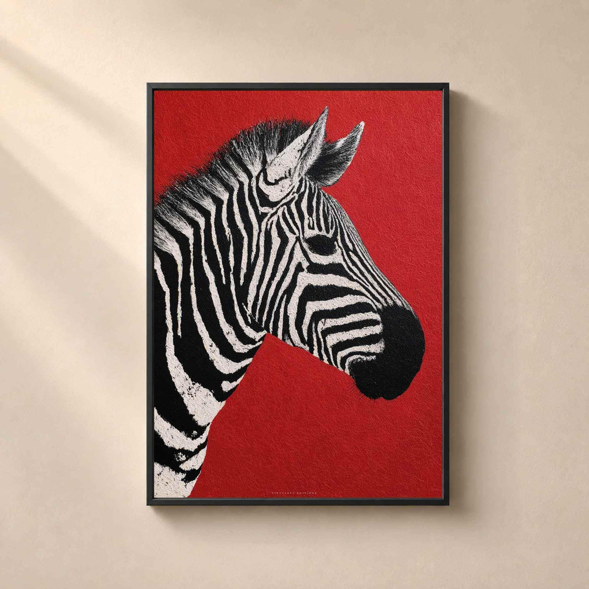 Affiche zèbre encadrée en métal noir fin sur un mur beige, tête rayée du zèbre se détachant sur un rouge profond et mat.