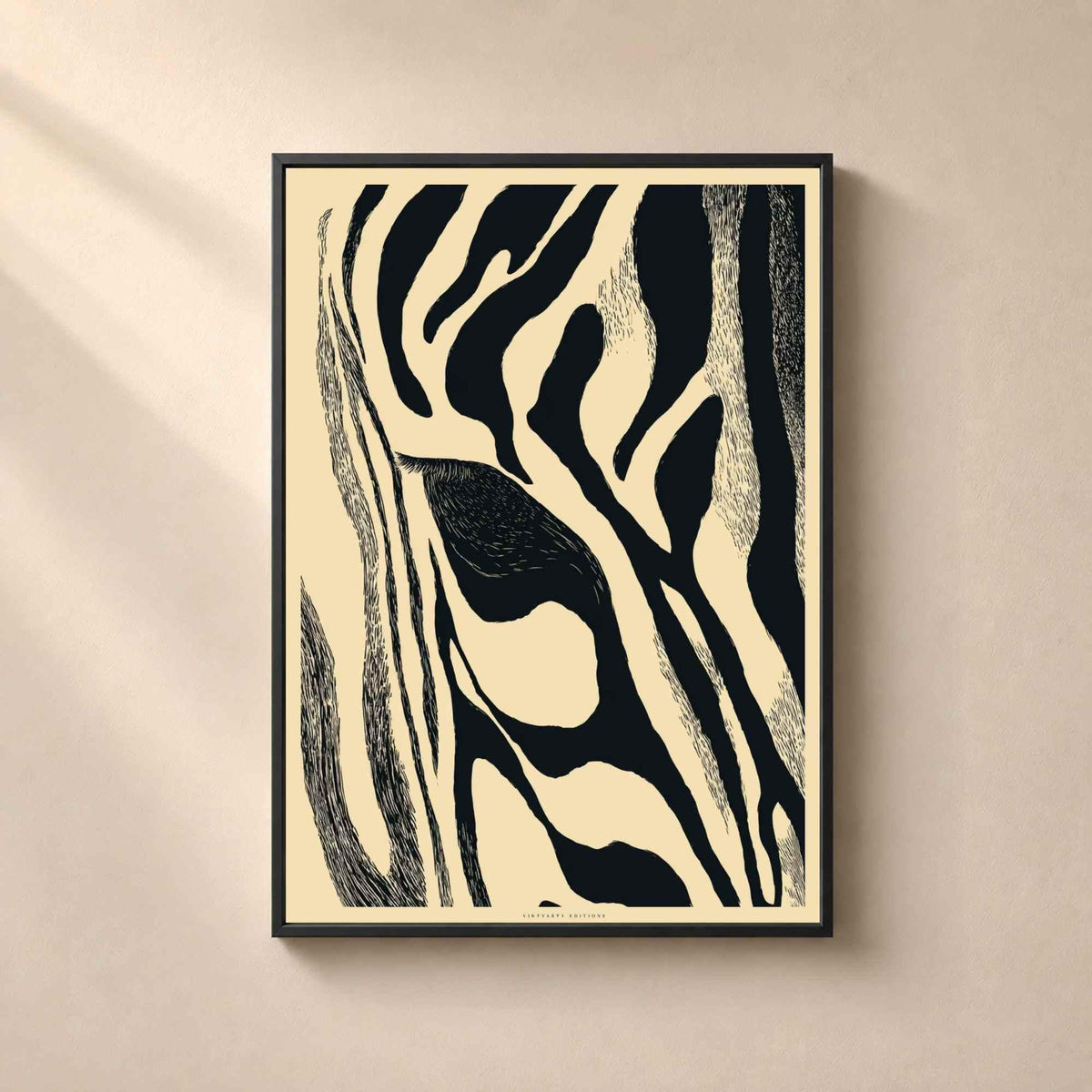 Affiche abstraite dans un cadre en chêne naturel sur un mur clair, rayures de zèbre noires et crème en gros plan formant un motif organique.