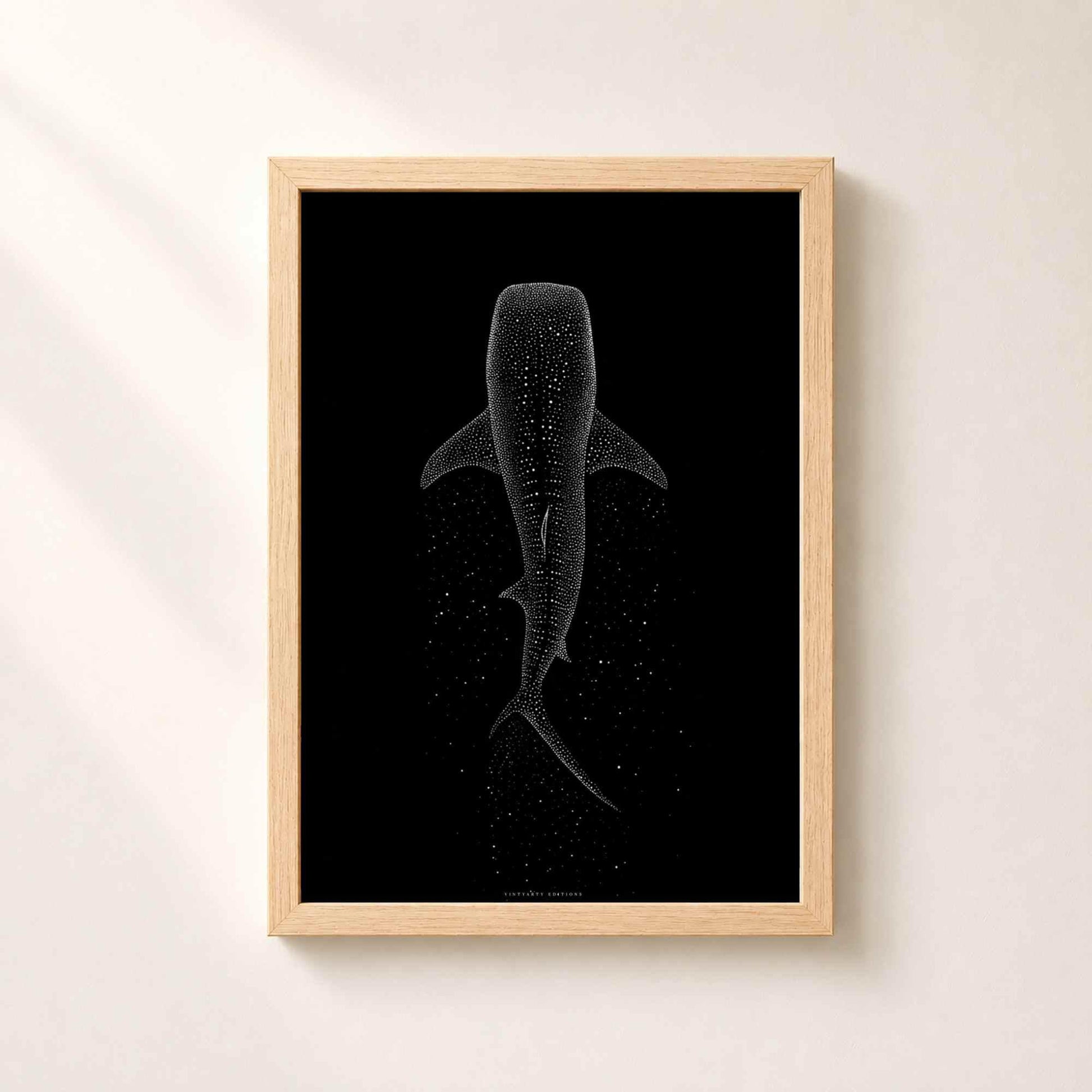 Affiche requin baleine dans un cadre en chêne naturel sur un mur clair, taches du requin dessinées en points blancs suspendus dans le noir.