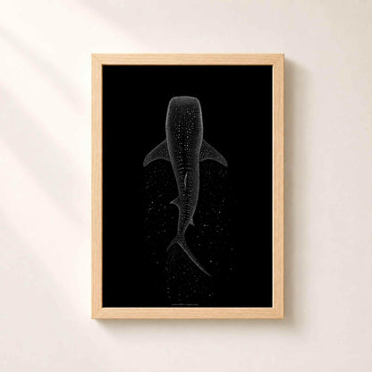 Affiche requin baleine dans un cadre en chêne naturel sur un mur clair, taches du requin dessinées en points blancs suspendus dans le noir.