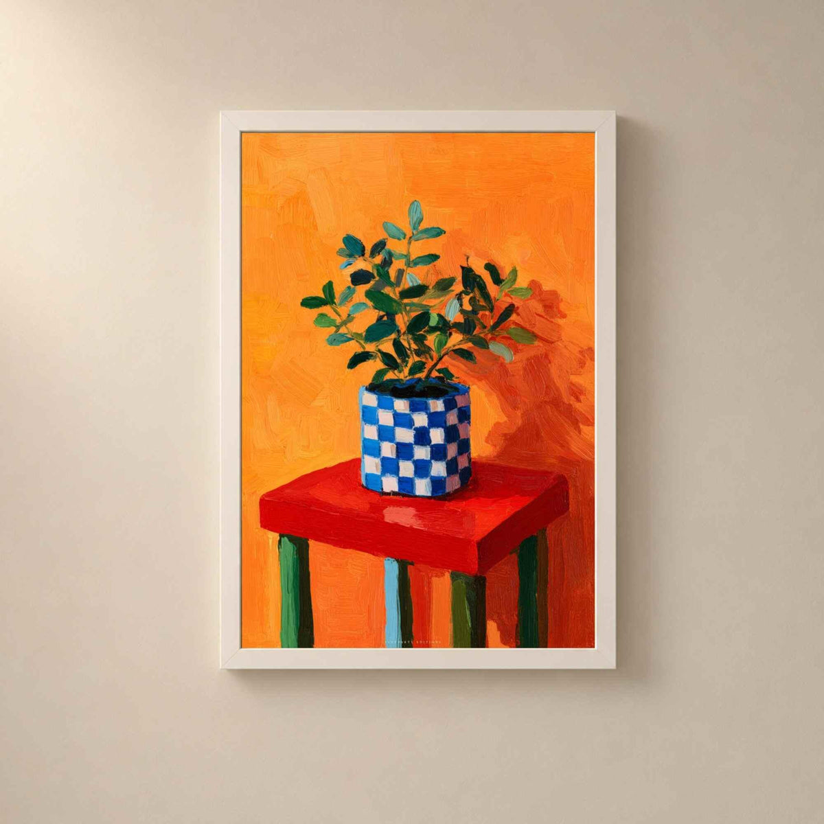 Affiche nature morte dans un cadre en bois blanc sur un mur clair, plante en pot damier bleu sur un tabouret rouge devant un fond orange vif.
